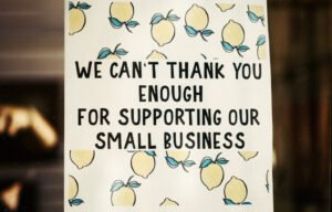 Small business thanks customers with sign in front of business
